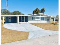 Light blue single story home with carport and screened porch at 8973 Sw 101St Ln, Ocala, FL 34481