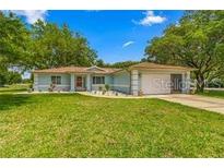 Ranch-style home with a carport and well-manicured lawn at 10557 Sw 62Nd Ct, Ocala, FL 34476