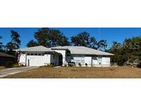 Single-story house with a light-colored exterior and a grassy front yard at 2849 Sw 140 Pl, Ocala, FL 34473