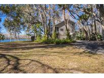 Two-story house with lake view, surrounded by lush trees and landscaping at 4925 Cr 309B, Lake Panasoffkee, FL 33538