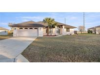 Single-story home with attached garage and landscaped lawn at 5525 Sw 80Th Pl, Ocala, FL 34476