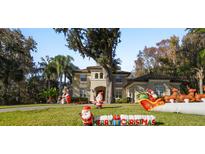 Two-story house with festive Christmas decorations, a large yard, and a paved driveway at 1219 Se 46Th St, Ocala, FL 34480