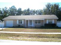 Ranch style home with a single car garage and a well-maintained lawn at 15120 Sw 39Th Cir, Ocala, FL 34473