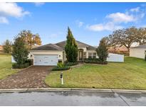 Single-story house with brick driveway, two-car garage, and landscaped lawn at 4314 Sw 65Th Pl, Ocala, FL 34474