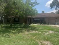 Ranch-style home with mature landscaping and a two-car garage at 4434 Se 10Th Pl, Ocala, FL 34471