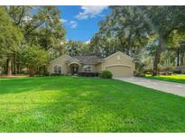 One-story house with a large front yard, driveway, and mature trees at 4977 Se 44Th Cir, Ocala, FL 34480