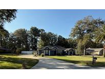 Ranch style home with mature landscaping and a long driveway at 5579 Se 44Th Cir, Ocala, FL 34480