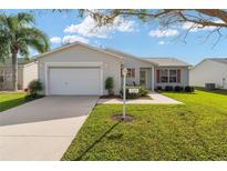One story home with attached garage, landscaped lawn and walkway at 3324 Oakdale Pl, The Villages, FL 32162