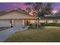 Charming single-story home featuring a well-manicured lawn and attached garage, set against a vibrant twilight sky at 8580 Sw 97Th Lane Rd # B, Ocala, FL 34481