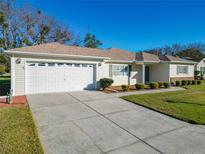 Single-story home with attached garage and well-manicured lawn at 9811 Se 138Th Loop, Summerfield, FL 34491