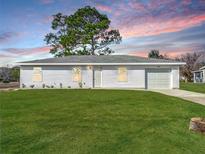 Newly constructed single-story home with a white exterior and a well-manicured lawn at 10856 Sw 79Th Ave, Ocala, FL 34476