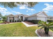 One-story house with gray siding, landscaping, and a two-car garage at 12531 Se 90Th Ter, Summerfield, FL 34491