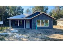 New construction home exterior, featuring a white door and windows at 2998 Se 140Th Ln, Summerfield, FL 34491