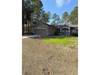 Single story home with attached garage, landscaping, and a walkway at 3 Maple Run, Ocala, FL 34472