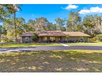 Single-story home with gray siding, brown roof, and a spacious yard at 3650 Se 22Nd Ave, Ocala, FL 34471