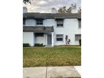 Light blue two-story townhome with a gray door and manicured lawn at 4503 Oak Arbor Cir, Orlando, FL 32808