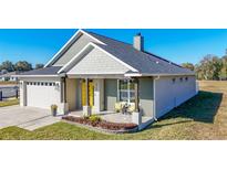 Charming house with a yellow door and landscaping at 4709 Se 25Th Loop, Ocala, FL 34480