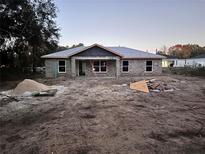 Newly constructed single-story home with a light gray exterior and landscaping to be completed at 5411 Nw 7Th Pl, Ocala, FL 34482