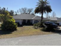 Single-story home with gray roof and landscaped yard at 5824 Sw 100Th Ln, Ocala, FL 34476