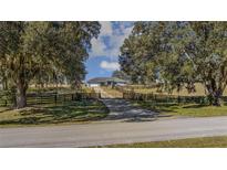 Ranch home with driveway, fenced pastures, and mature trees at 630 Sw 210Th Ave, Dunnellon, FL 34431