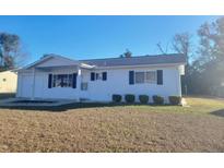 White single story home with a covered entryway and landscaped yard at 8200 Sw 107Th Ln, Ocala, FL 34481