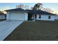 Single-story home with attached garage and grassy front yard at 8512 Sw 136Th Pl, Ocala, FL 34473