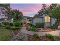 Beautiful home with landscaped walkway, lush greenery, and a pond feature at dusk at 1105 Se 48Th Ave, Ocala, FL 34471