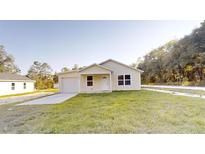 Newly constructed single-story home with a paved driveway and grassy yard at 15551 Sw 38Th Pl, Ocala, FL 34481