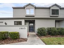 Two-story townhome with gray siding, a blue door, and well-manicured landscaping at 1903 Se 37Th Court Cir, Ocala, FL 34471