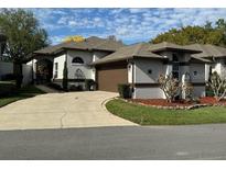 Single-story home with attached garage and landscaped yard at 2011 Se Twin Bridge Cir, Ocala, FL 34471