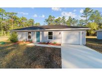 Newly built home with gray siding, teal front door, and garage at 2295 Sw 142Nd Court Rd, Ocala, FL 34481