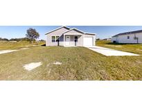 Newly constructed home with a gray exterior and a well-maintained lawn at 3290 Sw 151St Ave, Ocala, FL 34481