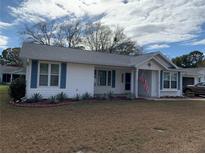 Single story home with white siding, gray roof, and landscaped yard at 8340 Sw 108Th Place Rd, Ocala, FL 34481