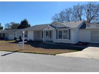 Single-story house with white exterior, landscaping, and a short driveway at 8340 Sw 108Th Place Rd, Ocala, FL 34481