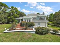 House exterior boasts a two-car garage and nicely landscaped front yard at 22777 Sw Surf Blvd, Dunnellon, FL 34431