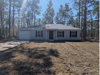 Newly constructed home with a well-maintained lawn at 24162 Nw Hemlock Ave, Dunnellon, FL 34431