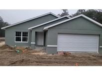 Newly constructed home with a gray exterior, two-car garage, and landscaping at 24300 Sw Sea Cliff Ave, Dunnellon, FL 34431