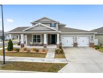 Two-story home with a front porch, two-car garage, and landscaped yard at 6115 Sw 74Th Ct, Ocala, FL 34474