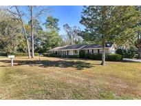 Ranch-style home with a spacious lawn and mature trees at 1105 Ne 17Th Ne Ter, Ocala, FL 34470