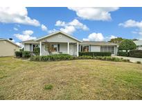 Single-story house with a covered porch, neatly landscaped lawn, and a driveway at 8188 Sw 108Th Loop, Ocala, FL 34481