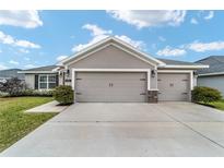 House exterior featuring a two-car garage and well-manicured lawn at 8405 Sw 59Th Ter, Ocala, FL 34476