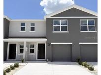 Contemporary townhome featuring a two-car garage, neutral paint scheme and a concrete driveway at 8410 Gower Trl, Wildwood, FL 34785