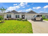 Single-story home with gray accents and a landscaped lawn at 1789 Usrey Ct, Okahumpka, FL 34762