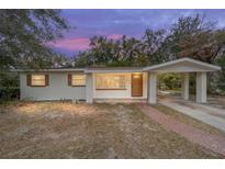 Inviting single-story home with a brick walkway and attached carport nestled amongst mature trees at 2501 Nw 20Th St, Ocala, FL 34475