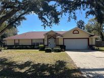 Charming single-story home featuring a two-car garage and a well-maintained front yard at 5980 Se 4Th Pl, Ocala, FL 34472