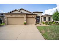 Two-story house with a three-car garage and landscaped lawn at 7646 Sw 100Th Ct, Ocala, FL 34481