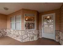 Inviting front porch featuring stone accents, and a clear view of the entrance at 9051 Sw 96Th Ln # B, Ocala, FL 34481