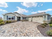 Single-story home with three-car garage and paver driveway at 9253 Sw 86Th Pl, Ocala, FL 34481