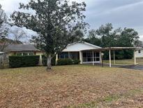 Ranch-style home with carport and mature landscaping at 9359 Bahia Rd, Ocala, FL 34472