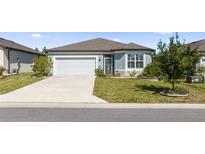 Single-story home with a two-car garage and well-manicured lawn at 9411 Sw 54Th St, Ocala, FL 34481